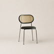 Chair with woven backrest and black seat on a beige background