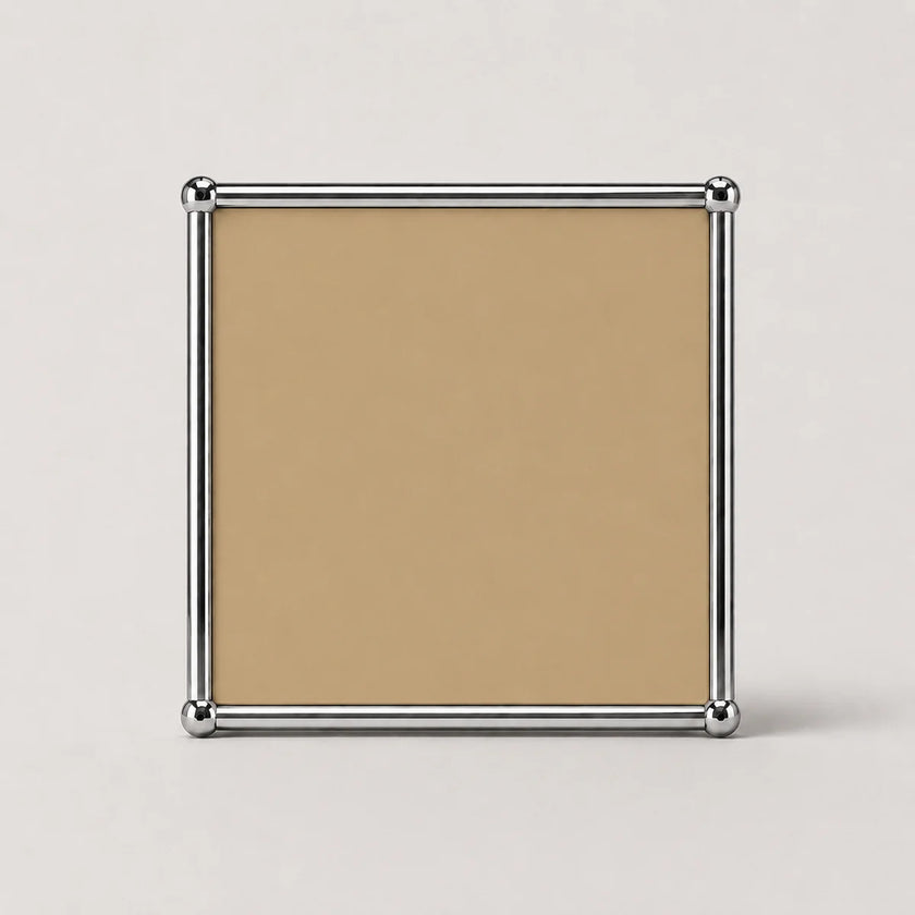 A square tan or beige metal panel print with a polished silver metal border and corner caps, shown against a light gray background.