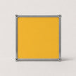 A square yellow plaque or sign with a polished silver metal frame, shown against a light gray background.