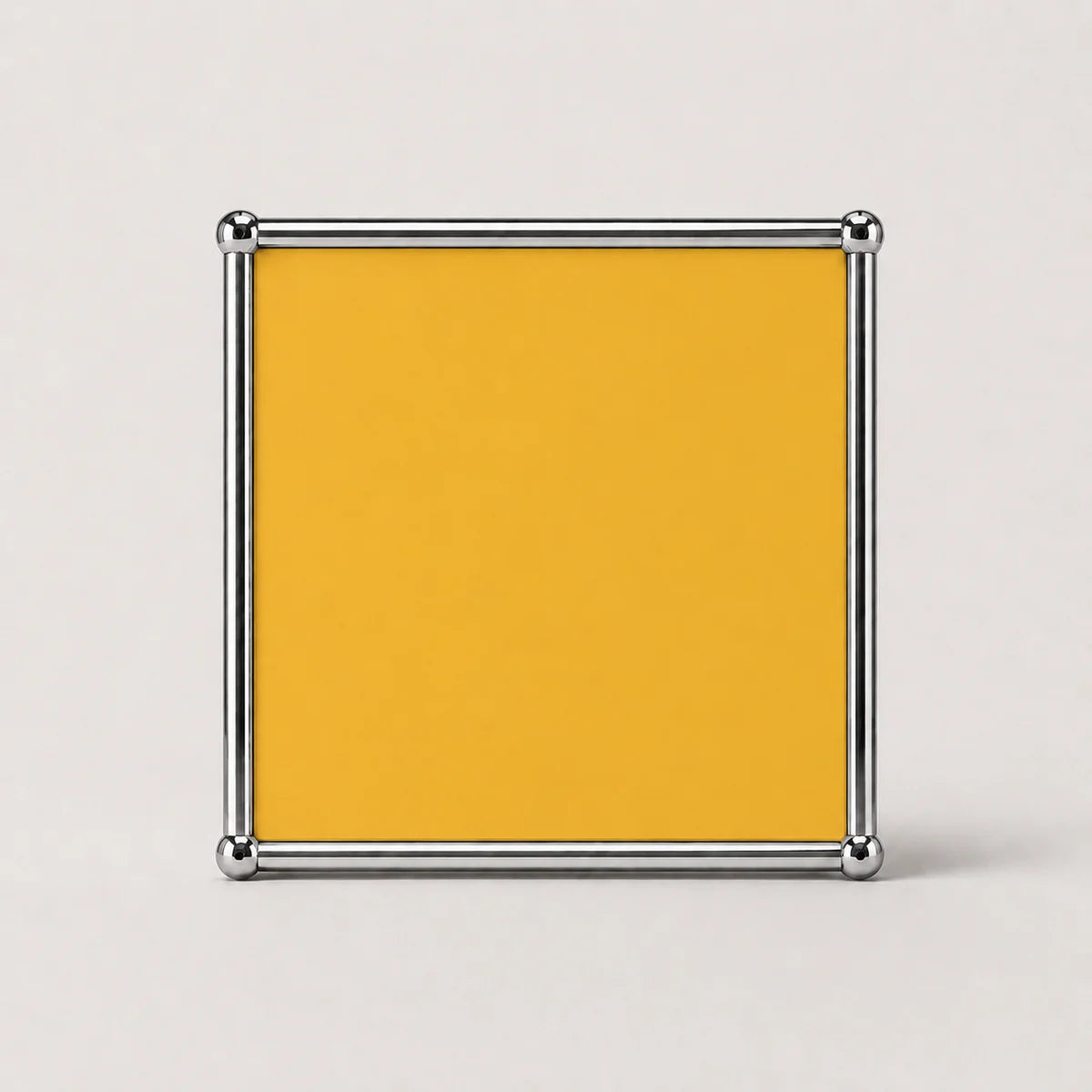 A square yellow plaque or sign with a polished silver metal frame, shown against a light gray background.