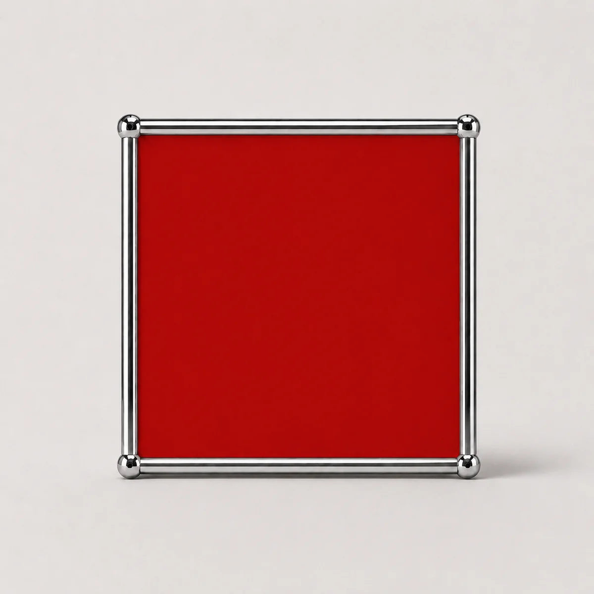 A square ruby red plaque or sign with a polished silver metal border and corner caps, shown against a neutral light gray background.