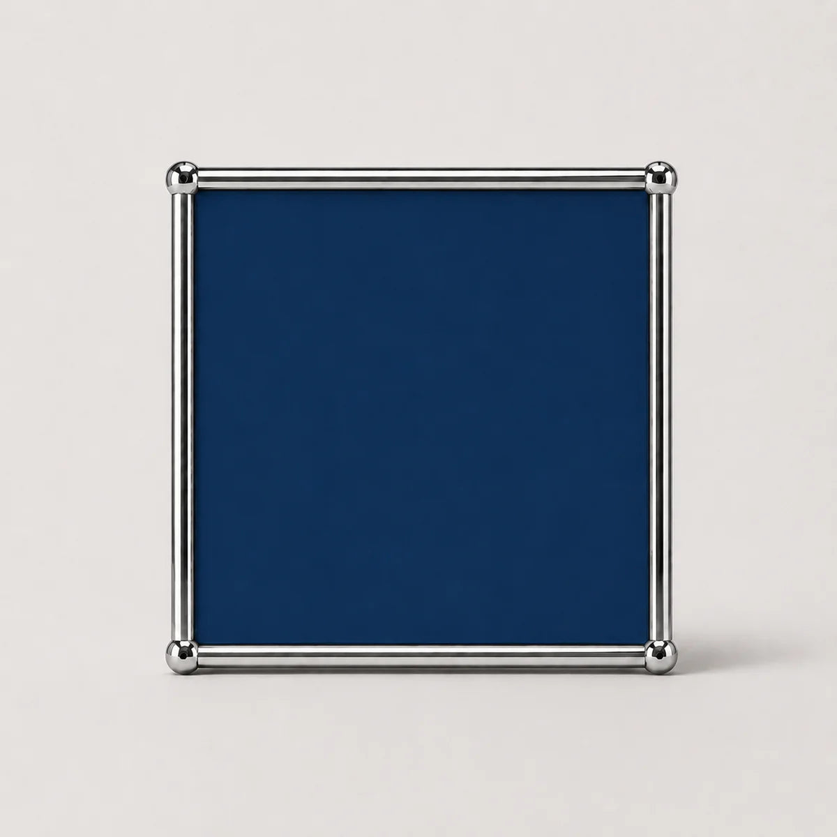 A square steel blue plaque or sign with a polished silver metal frame and corner protectors, shown against a light gray background.