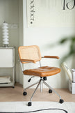 Brown office arm chair with woven backrest in a room setting.