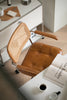 Brown leather office wassily chair with wicker backrest in a home office setting.