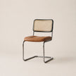 Chair with brown leather seat and wicker back on a beige background