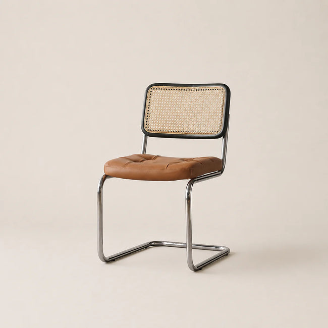 Chair with brown leather seat and wicker back on a beige background