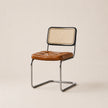 Chair with brown leather seat and wicker back on a beige background