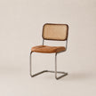 Chair with brown leather seat and wicker back on a beige background