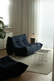 Modern living room with dark blue love seat sofa and a small table.