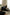 Women sitting on love seat sofa in a living room, one reading a book.