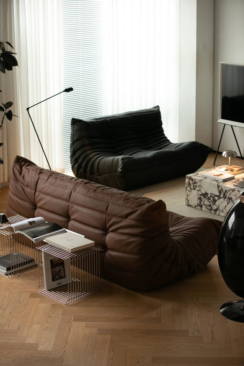 Modern living room with brown leather sofa, black love seat sofa, and coffee table.