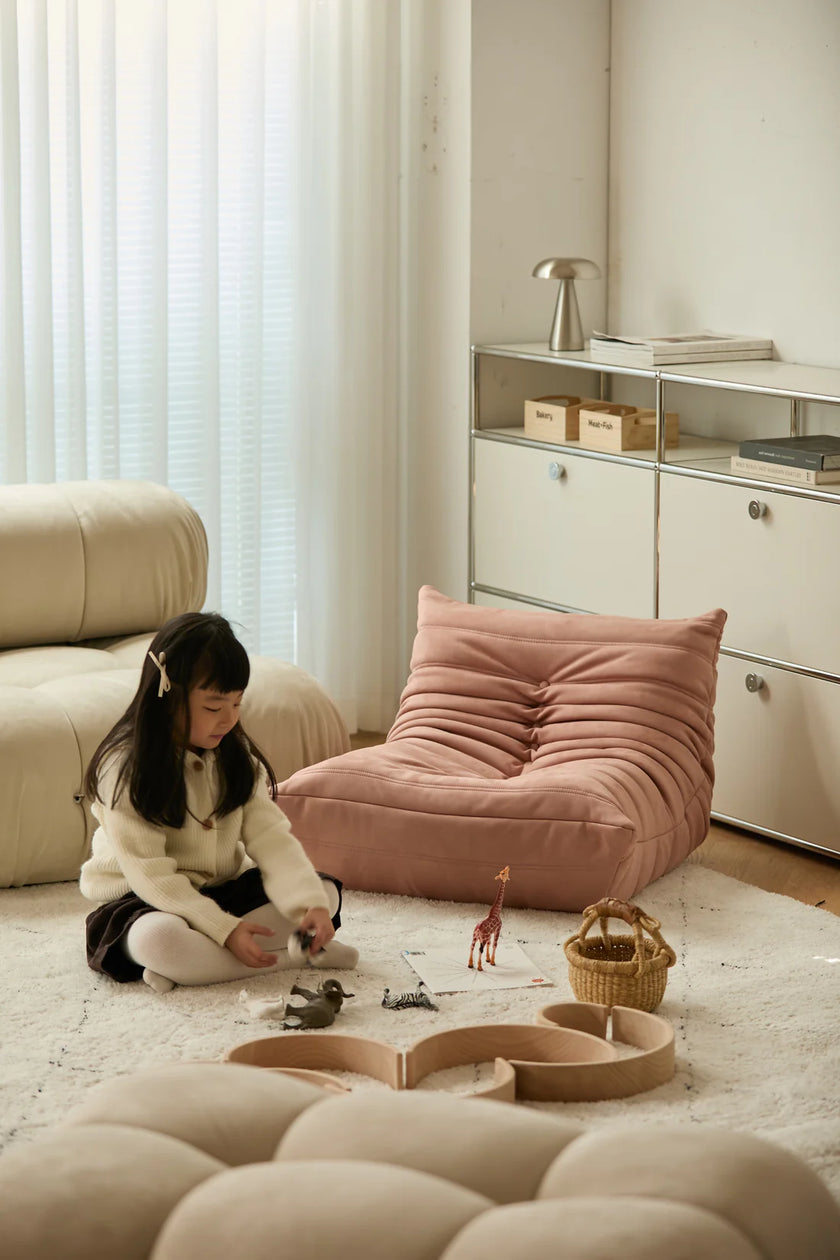 Child playing with toys on a beige rug in a modern living room.