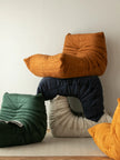 Stack of colorful modern sofa on a light wooden floor against a white wall