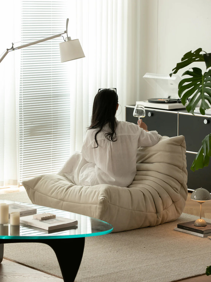 Women sitting on a large beige leather sofa in a modern living room.