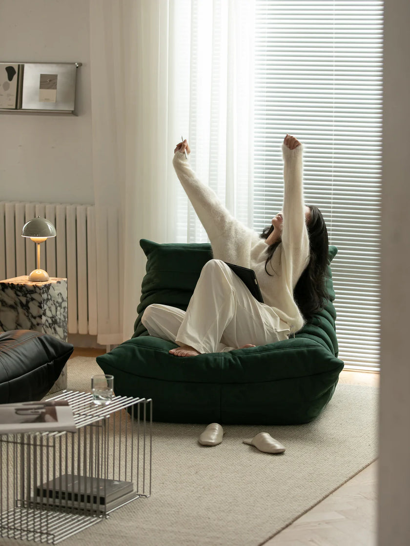 Women sitting on a green lounge sofa in a modern living room.