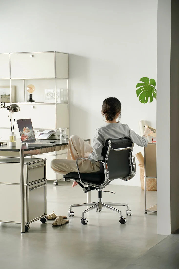 Person sitting at a desk with a laptop in a modern office setting