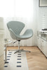 Modern office leather swivel chair in a minimalistic office setting with white walls and wooden floor.