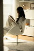Lady reading a book with leather swivel chair in a modern living room.