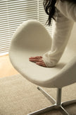 Women sitting on a modern chair with a blurred background