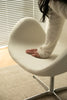 Women sitting on a modern chair with a blurred background