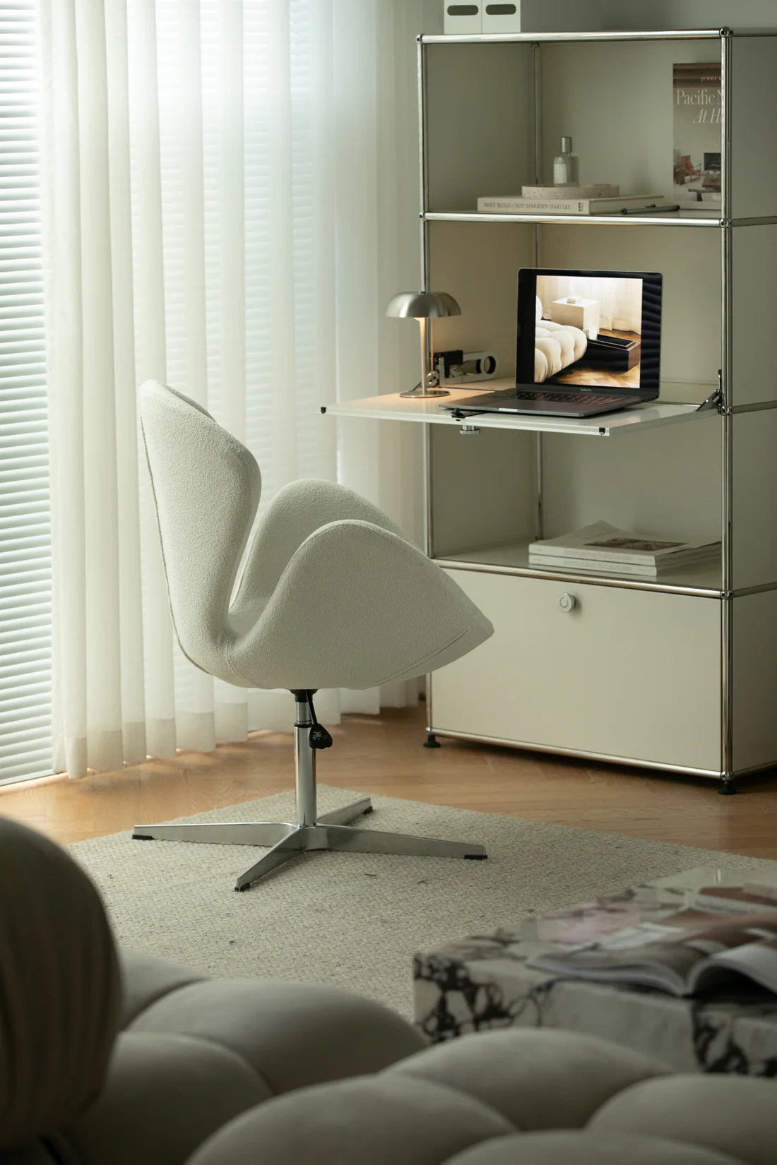 Modern home office with a white chair, desk, and shelves.