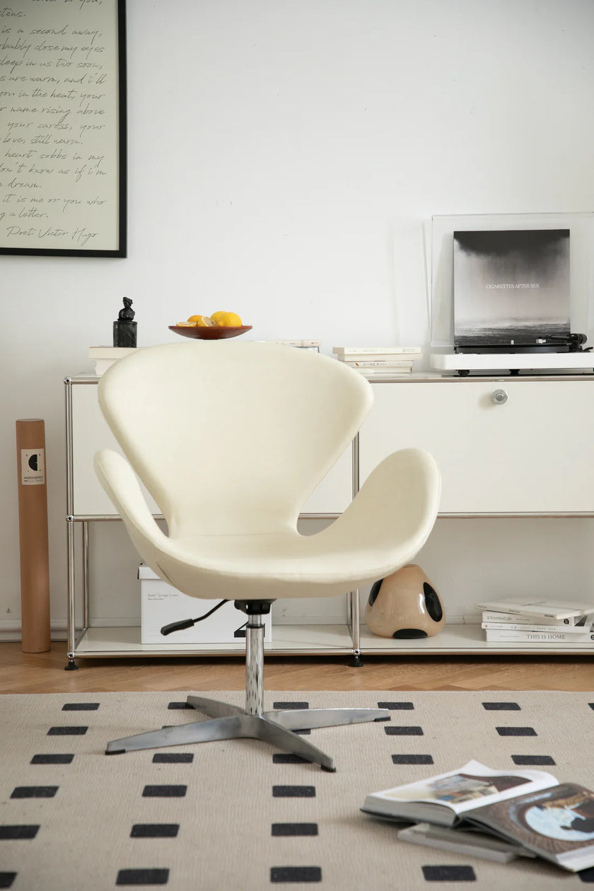 White leather swivel chair in a modern living room with a rug and books.