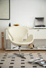 White leather swivel chair in a modern living room with a rug and books.
