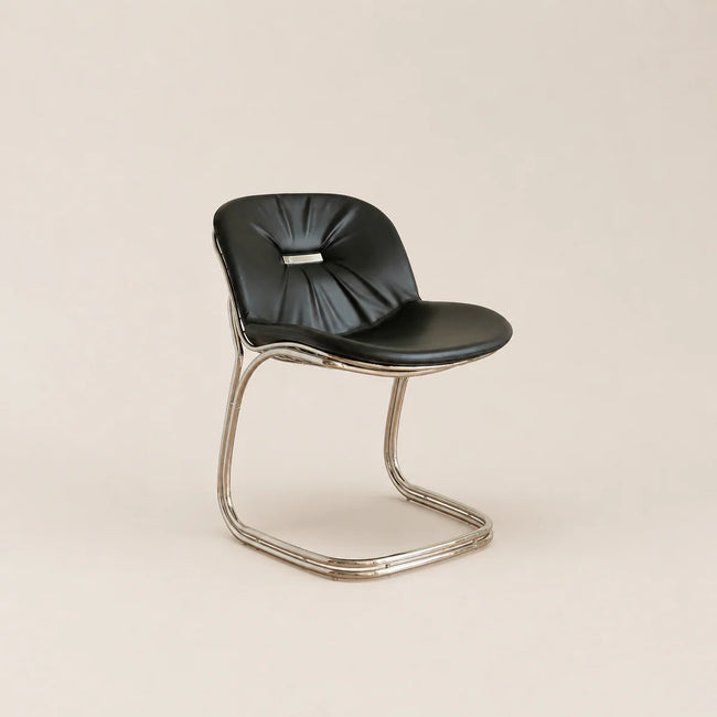 Black chair with a minimalist design on a beige background