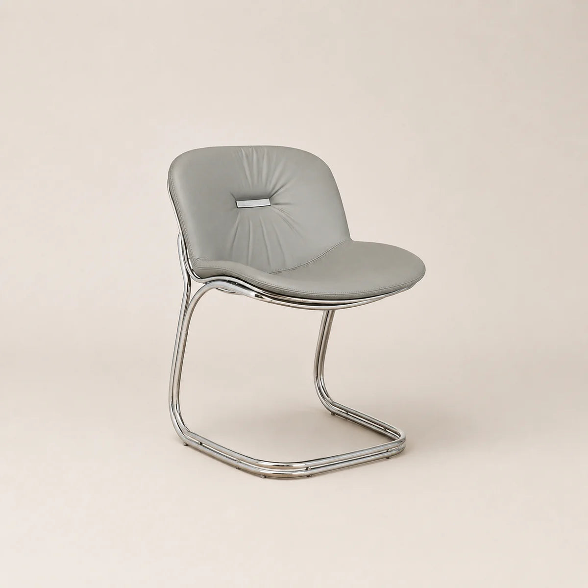 Modern chair with a gray cushioned seat and chrome frame on a beige background