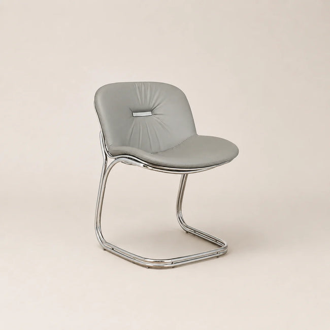 Modern chair with a gray cushioned seat and chrome frame on a beige background