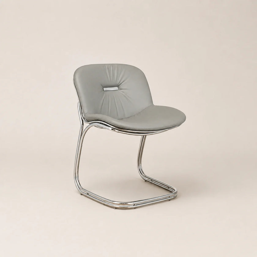 Modern chair with a gray cushioned seat and chrome frame on a beige background