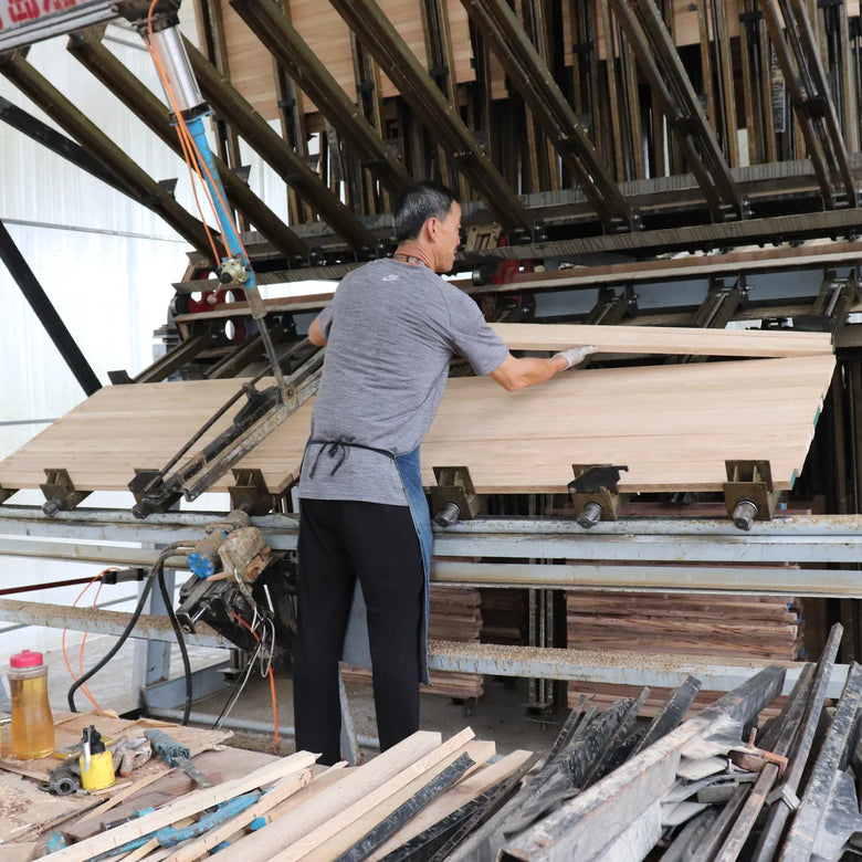 Person working with wooden panels in a factory setting