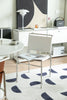 Modern office space with a desk, leather dining chair, and decorative elements.