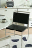 Black dining chair with metal frame in a modern interior setting