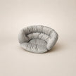 Light gray pet bed on a beige background