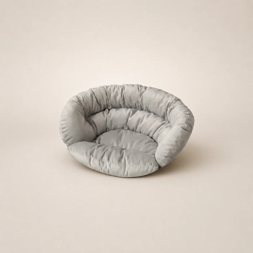 Light gray pet bed on a beige background