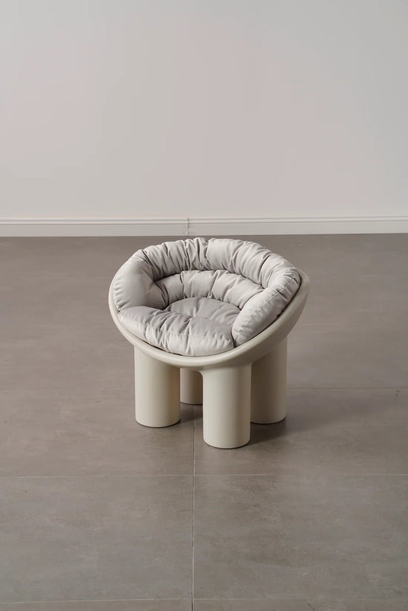 Modern plastic toddler chair with a cushion on a gray floor and white wall