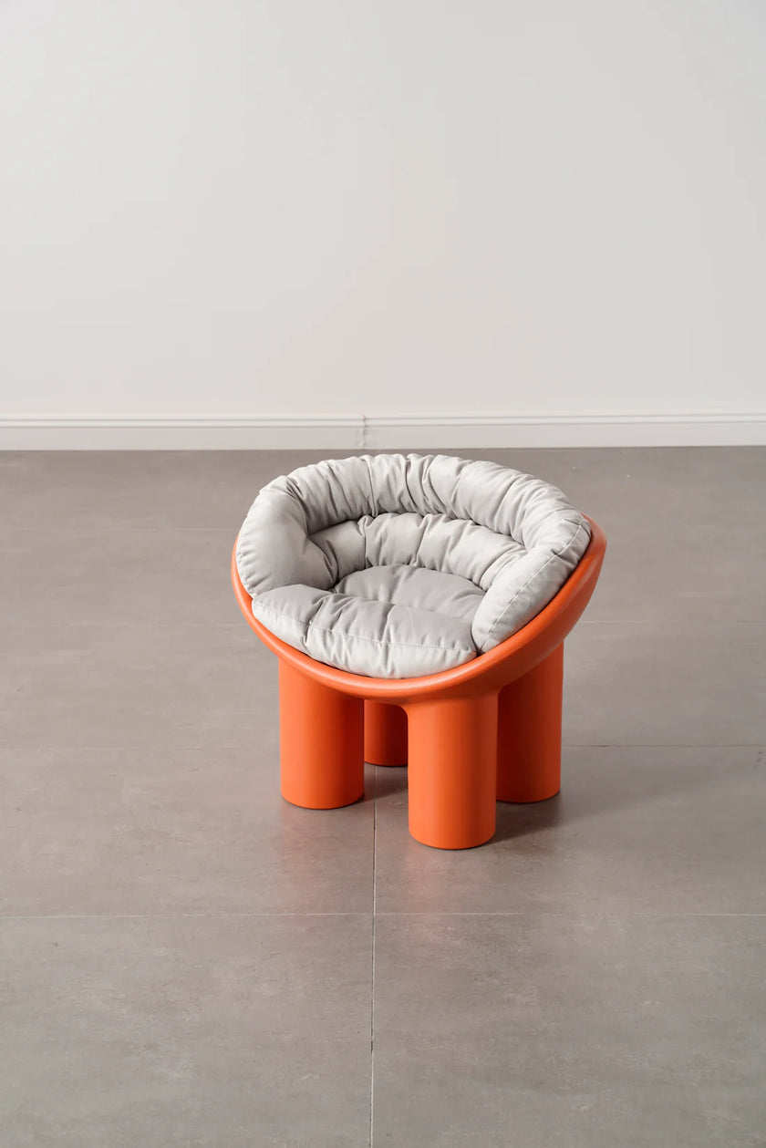Orange kids toys chair with a gray cushion on a plain floor.