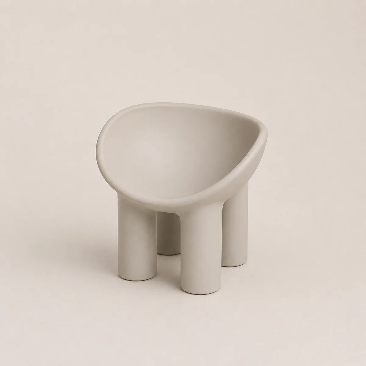 A minimalist, modern low PE stool with a rounded, bowl-like seat and four cylindrical legs, finished in a matte light gray color, set against a solid light beige background.