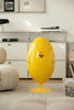 Yellow egg-shaped recycle bin with Superman logo in a modern living room.