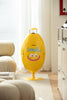 Yellow smiley face-shaped recycle bin with 'smile' text in a living room.