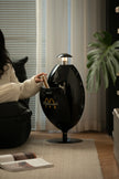 Lady sitting on a black chair with McDonald's logo house recycle bin in a living room setting.