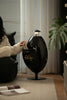 Lady sitting on a black chair with McDonald's logo house recycle bin in a living room setting.