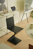 Modern black counter chair in a minimalistic room with a TV and decor items.