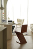 Modern interior with a brown wooden chair, round table, and white sofa.