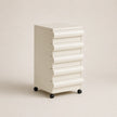 White cylindrical storage unit on wheels against a beige background