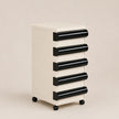 White and black drawer unit on wheels against a beige background