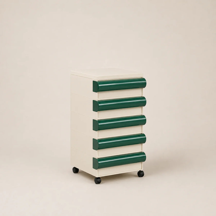 Small storage cabinet with green drawers on a beige background