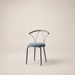 Chair with black metal frame and blue cushion on a beige background