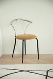 Metal chair with metal frame and beige cushion on a wooden floor.